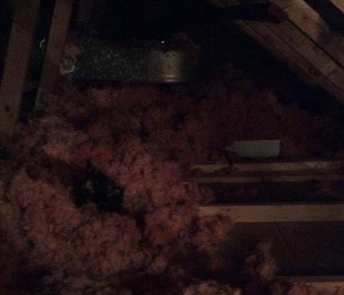 an attic space with wood planks and pink insulation